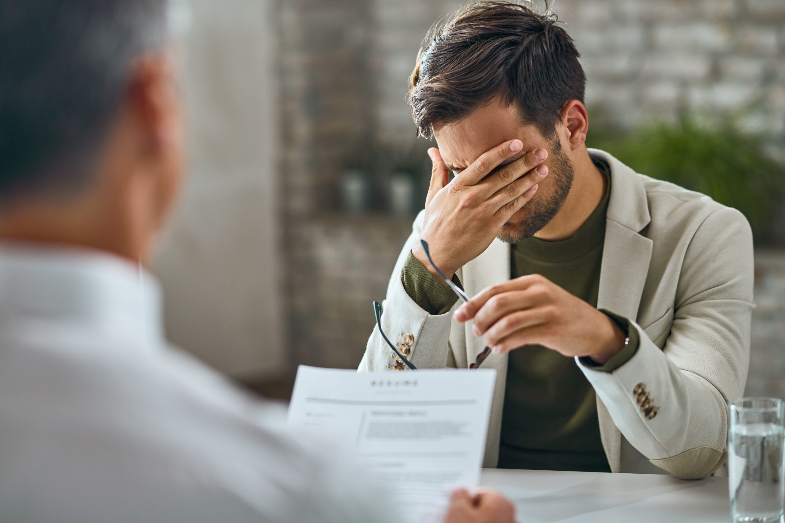 Worried male candidate having a job interview with a manager in the office.
